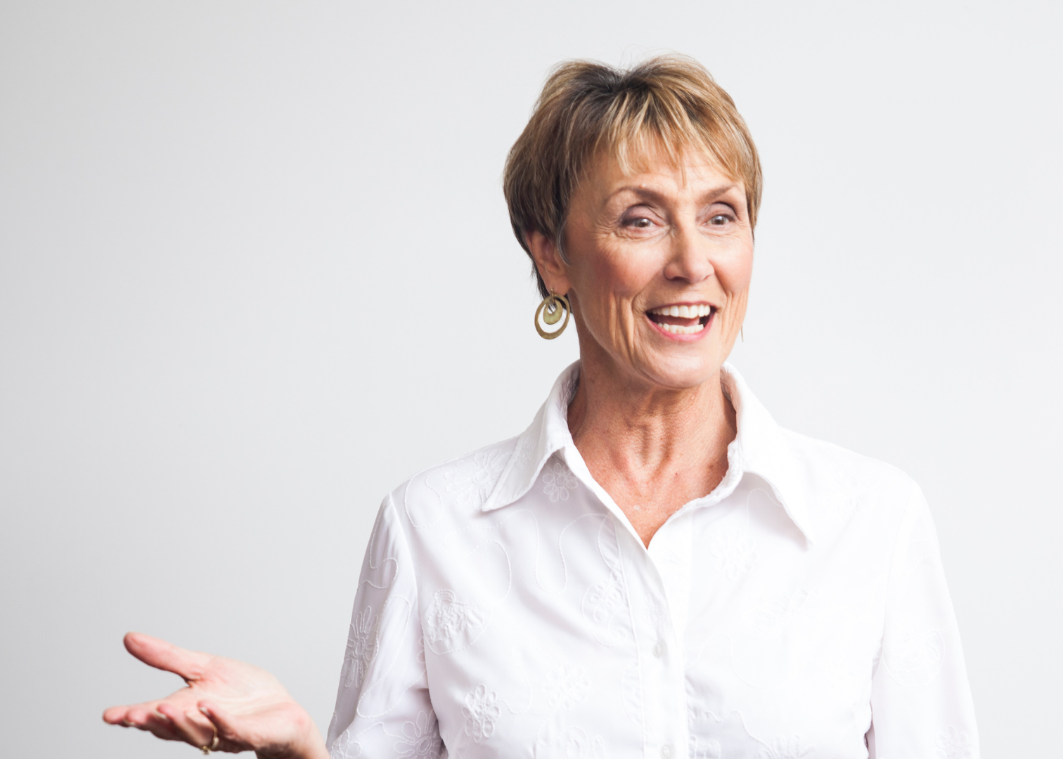woman in white shirt with hand out speaking