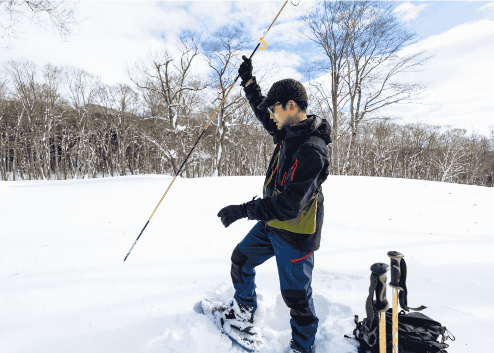 man using avalanche probe in the snow